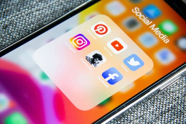 Eine Nahaufnahme eines Smartphone-Bildschirms mit einem Ordner mit der Bezeichnung „Startup Coaching“, der Symbole für verschiedene Social-Media-Plattformen enthält, darunter Instagram, Pinterest, YouTube, WhatsApp, Facebook und Twitter.