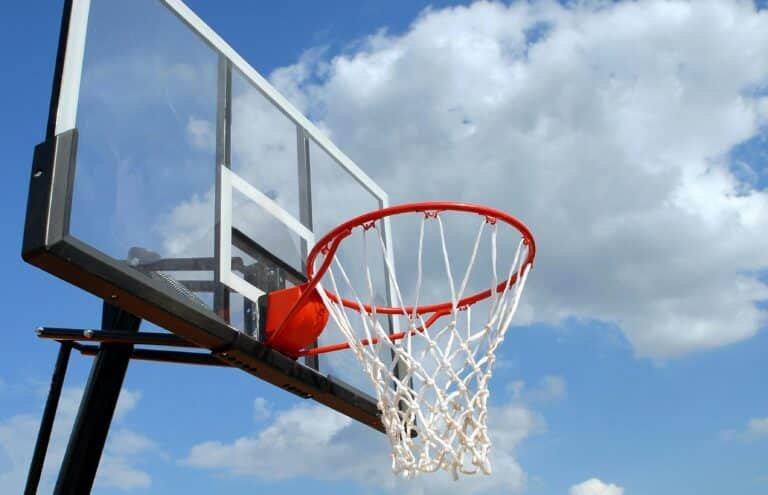 Basketballkorb im Freien vor dem Hintergrund eines blauen Himmels mit vereinzelten Wolken, der an das grenzenlose Potenzial erinnert, das vom Startup-Coaching gepriesen wird.
